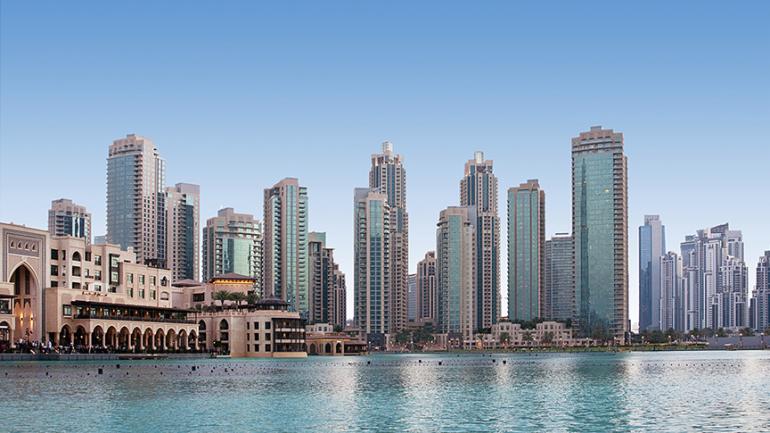Foto von Dubai. Im Vordergrund der Persische Golf und im Hintergrund die Skyline der Stadt.