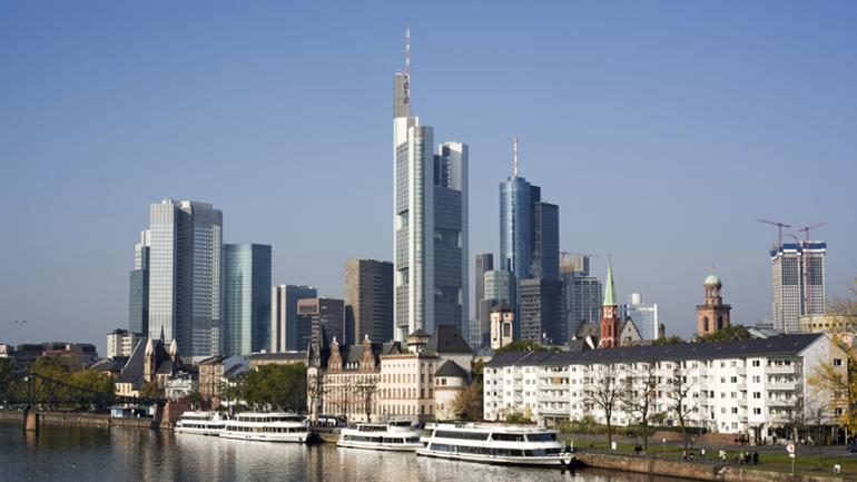 Foto von der Stadt Frankfurt am Main. Im Vordergrund der Main und dahinterliegend die Hochhäuser.
