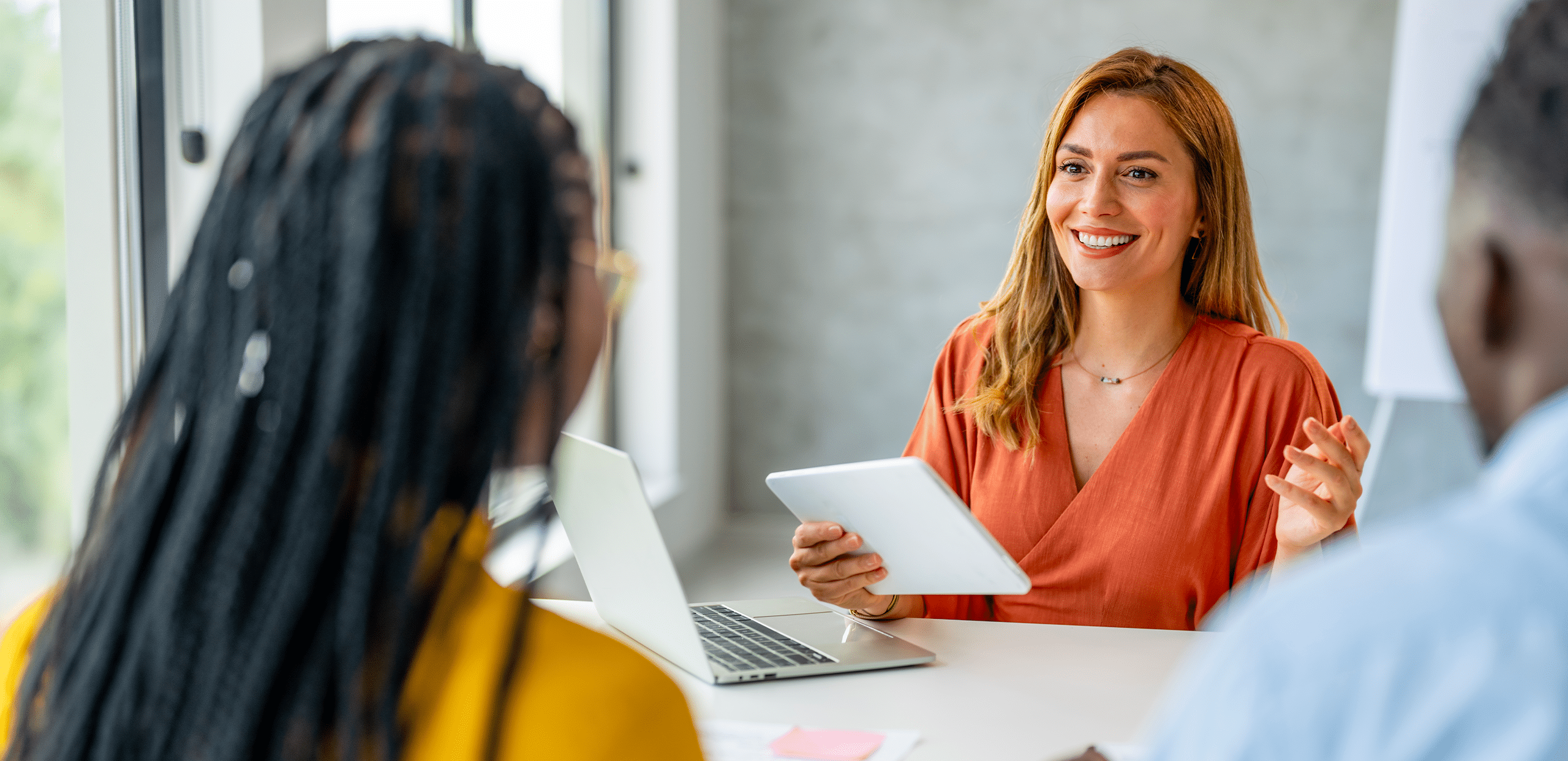 HR transformation workshop at EnBW: a consultant facilitates a people-focused discussion with employees, using a tablet during a collaborative meeting that reflects Detecon’s approach to modernizing HR processes, employee experience, and organizational change.