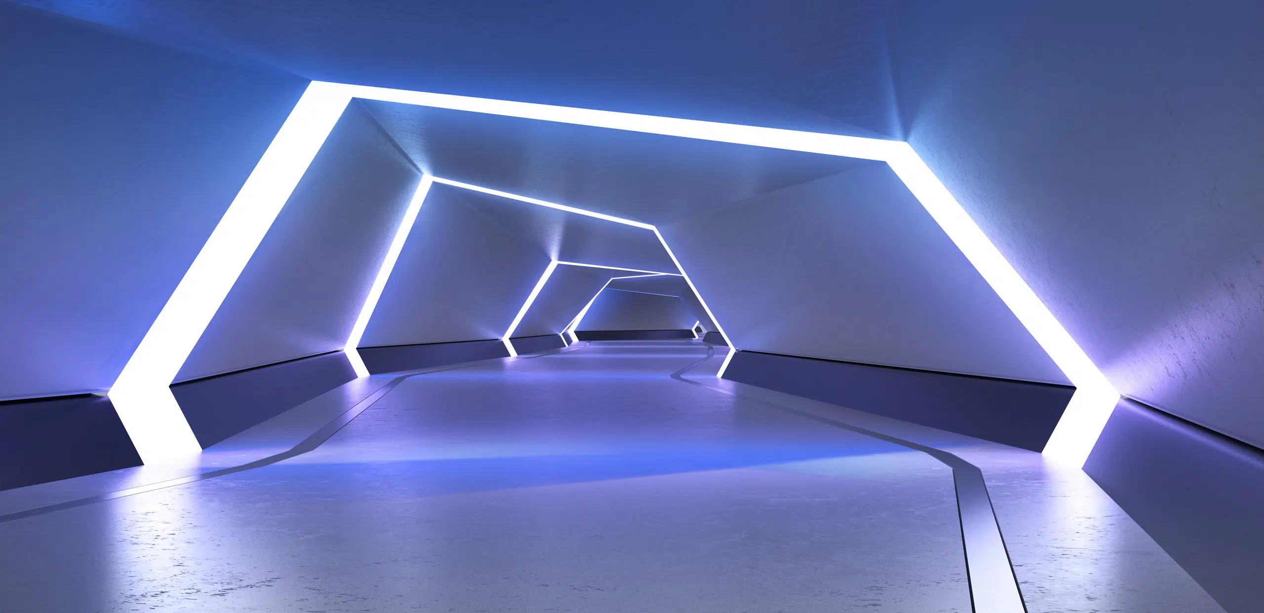 A futuristic, empty tunnel with angular white LED light frames lining the walls and ceiling, creating a glowing geometric pathway with cool blue lighting and a smooth reflective floor.