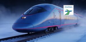 A sleek, modern high-speed train with a streamlined blue nose sits on snow-covered railway tracks in a misty winter setting. The train features thin pink accent lines along its body. An "InnoTrans" logo is overlaid in the upper-right corner of the image, suggesting a rail industry exhibition or promotional graphic.