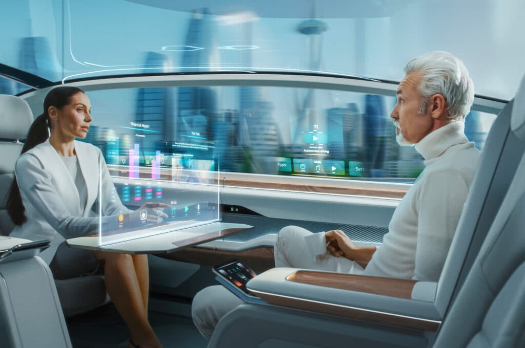 A casual business meeting between a senior male and a senior female in a futuristic driverless autonomous car featuring an augmented reality presentation interface